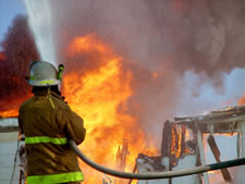 Image of Firefighter Spraying Water on Fire